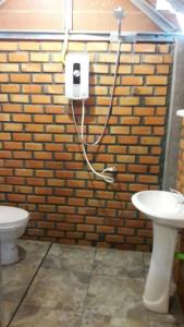 ein Badezimmer mit einer Backsteinwand, einem WC und einem Waschbecken in der Unterkunft Meechok organic home in Ao Nang Beach