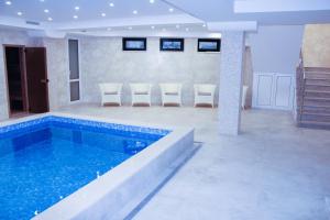 a large swimming pool with chairs in a room at Familion ApartHotel in Chişinău