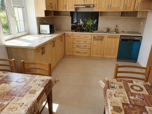 a kitchen with wooden cabinets and a table and chairs at Villa Petko in Vysoke Tatry - Dolny Smokovec +28 photos