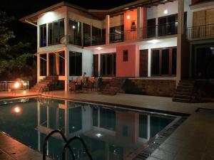 a house with a swimming pool at night at Lotus Villa Kandy in Peradeniya