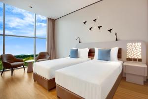 - 2 lits dans une chambre d'hôtel avec des oiseaux sur le mur dans l'établissement Lemon Tree Hotel, Jumeirah Dubai, à Dubaï