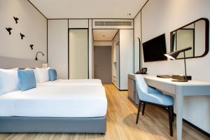 a hotel room with a bed and a desk at Lemon Tree Hotel, Jumeirah Dubai in Dubai