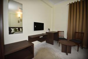 a hotel room with a desk and a television at The Narayans in Jaipur