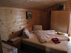 ein Schlafzimmer mit einem Bett in einer Holzwand in der Unterkunft Stampferhof in Matrei in Osttirol