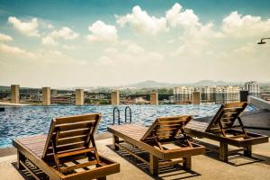 two chairs and a table next to a body of water at Thermospace Imperio A-17-19 Melaka City in Melaka