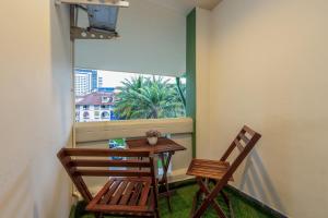 a table and two chairs on a balcony with a window at Tee Pak Dee Resident Phuket in Phuket