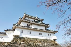a tall white building on top of a wall at HOTEL MYTH-WA -ホテル マイス ワ- adult only in Wakayama