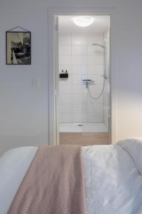a bathroom with a shower and a bed in a room at Q-Stay in Antwerp +18 photos
