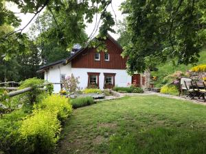 a white house with a red roof and a yard at Chalupa Pod Skalou I. in Paseky nad Jizerou