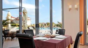 a dining room with a table and a view of a pool at Byala Panorama Resort in Byala