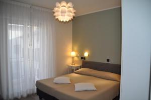sypialnia z łóżkiem z 2 białymi poduszkami w obiekcie Hotel Regina w Grado