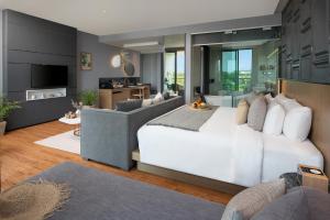 a bedroom with a white bed and a living room at Wyndham Grand Nai Harn Beach Phuket in Nai Harn Beach
