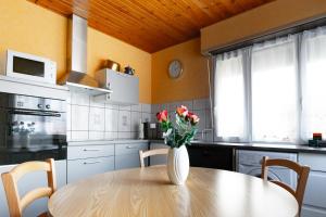 una cocina con una mesa con un jarrón de flores. en Gîte d’Anna, en Mackenheim
