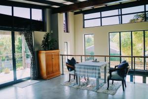 a dining room with a table and chairs and windows at 9 Windsor House in Tokai