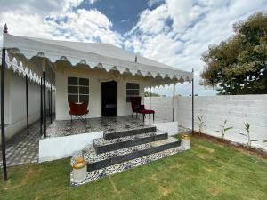 a small white house with a white roof and stairs at 16 Bedouin Private Pool Villa in Hosūr