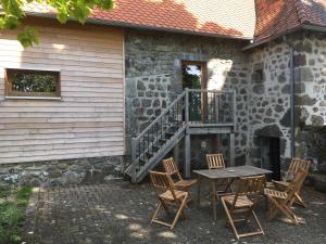 einen Tisch und Stühle vor einem Steinhaus in der Unterkunft La cavalièra in Polminhac