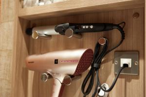 a hair dryer and a blow dryer on a wall at HOTEL MYTH-WA -ホテル マイス ワ- adult only in Wakayama