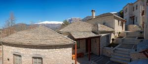 a group of brick houses with mountains in the background at Artsistas Houses in Aristi