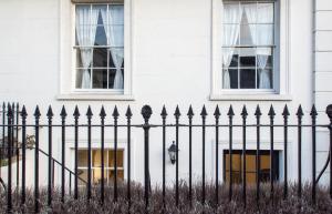 a black fence in front of a white house at Dale Street Apartments Suite in Leamington Spa