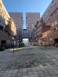 an empty courtyard in a city with tall buildings at Bicocca Flat F in Milan