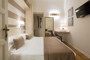 a hotel room with a white bed and a desk at Mediterraneo Emotional Hotel & Spa in Santa Margherita Ligure