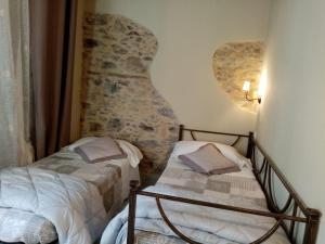 a bedroom with two beds and a stone wall at Casa D'amore in Riomaggiore