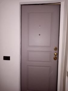 a white door with gold knobs next to a white wall at Casa D'amore in Riomaggiore