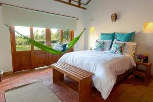 a bedroom with a bed with a hammock in it at Casa de las Flores in Villa de Leyva