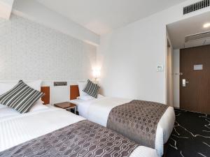 Ένα ή περισσότερα κρεβάτια σε δωμάτιο στο HOTEL MYSTAYS Sapporo Station