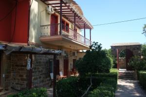 a building with a balcony on the side of it at Manganos Apartments in Kambos