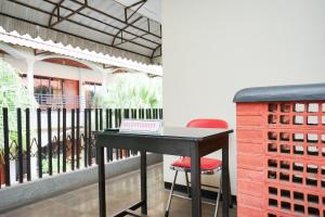 - une table avec un livre à côté d'un balcon dans l'établissement OYO Life 2090 Ratna Backpacker Syariah, à Probolinggo