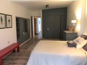a bedroom with a large white bed and a red bench at Casa Drummond in Ciudad Lujan de Cuyo +40 photos