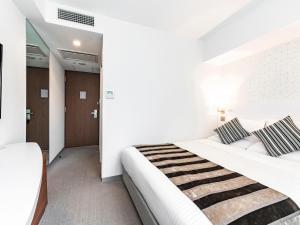 Ένα ή περισσότερα κρεβάτια σε δωμάτιο στο HOTEL MYSTAYS Sapporo Station