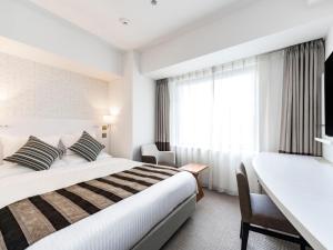 Ένα ή περισσότερα κρεβάτια σε δωμάτιο στο HOTEL MYSTAYS Sapporo Station