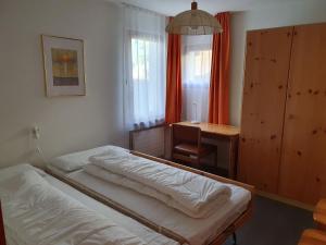 1 dormitorio con 2 camas, mesa y escritorio en Alpen-fewo, Denter Vias 10, Casa Alma en Flims