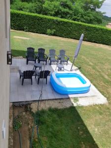 a swimming pool with chairs and a table and aitating at Appartement La Haute Preze & Golffrance in Rouzède