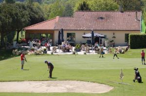 un gruppo di persone che giocano a golf su un campo da golf di Appartement La Haute Preze & Golffrance a Rouzède