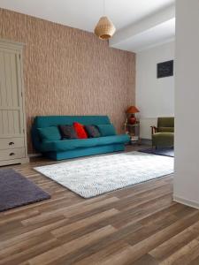 a living room with a blue couch and a rug at Happy Holiday Apartments in Predeal