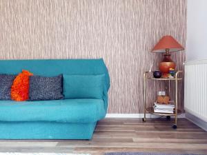 a blue couch in a living room with a lamp at Happy Holiday Apartments in Predeal