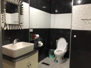 a bathroom with a white toilet and a sink at Out Back in Olongapo