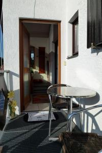 um pátio com uma mesa e cadeiras em frente a uma porta em Blindert em Mechernich