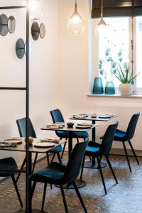 a dining room with four tables and blue chairs at B&B Achilles in Ghent