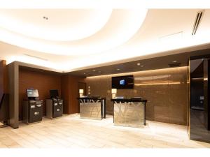 a lobby of a hotel with a television and a lobby at Place Hotel Ascot in Kumamoto