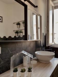 baño con espejo grande y lavabo en GREEN HOUSE en Roma