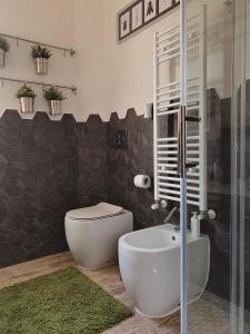 La salle de bains est pourvue de toilettes et d'une douche en verre. dans l'établissement GREEN HOUSE, à Rome