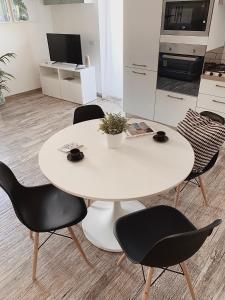 een witte tafel en stoelen in de woonkamer bij GREEN HOUSE in Rome