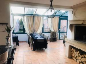 a dining room with a table and a fireplace at Aux Berges de Sambre in Aymeries