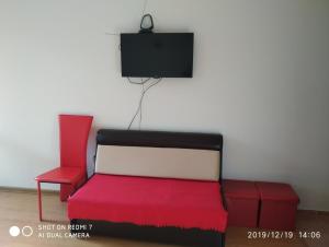 ボロヴェッツにあるStudio Chamkoriyaのリビングルーム(赤い椅子2脚、テレビ付)
