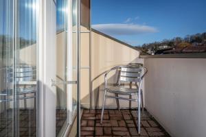 two chairs sitting on a balcony with a view at MyBednBreakfast in Bottmingen in Bottmingen