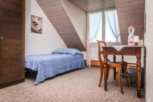 1 dormitorio con cama, escritorio y mesa en MyBednBreakfast in Bottmingen, en Bottmingen